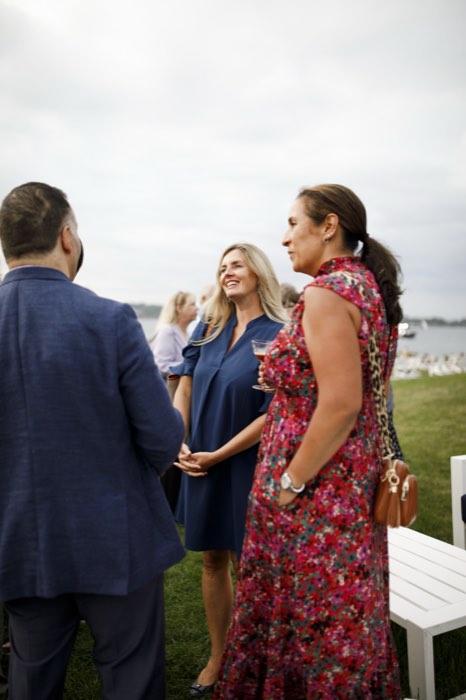 Three guests talking on the lawn.