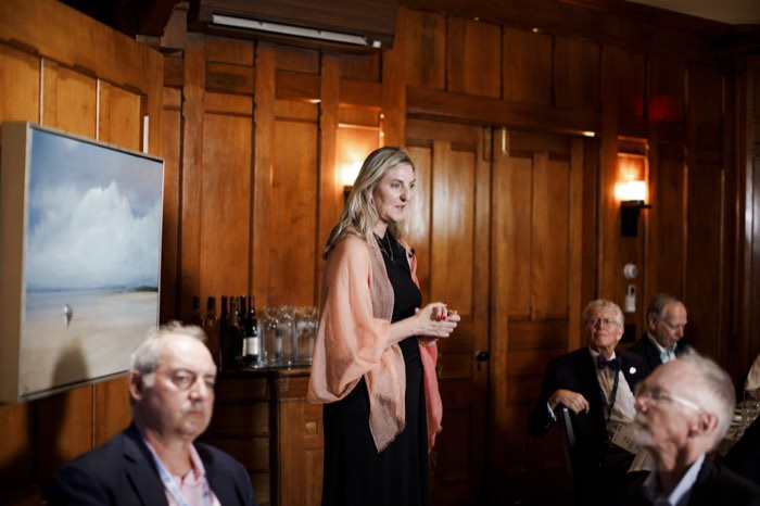 Susan Lindeque speaking to the tables, the room turned to listen.