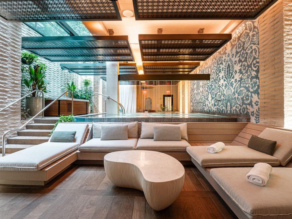 The relaxation lounge at the Spa at Seafire, with cream loungers and a sculpted coffee table beside a patterned blue tile wall