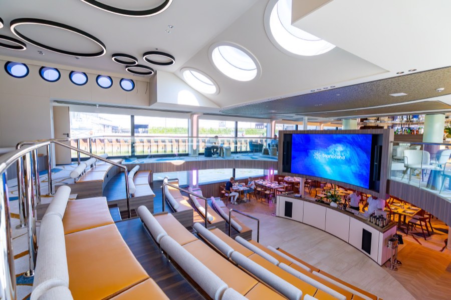 The Forum's tiered amphitheater seating and wraparound screen aboard Transcend Connect