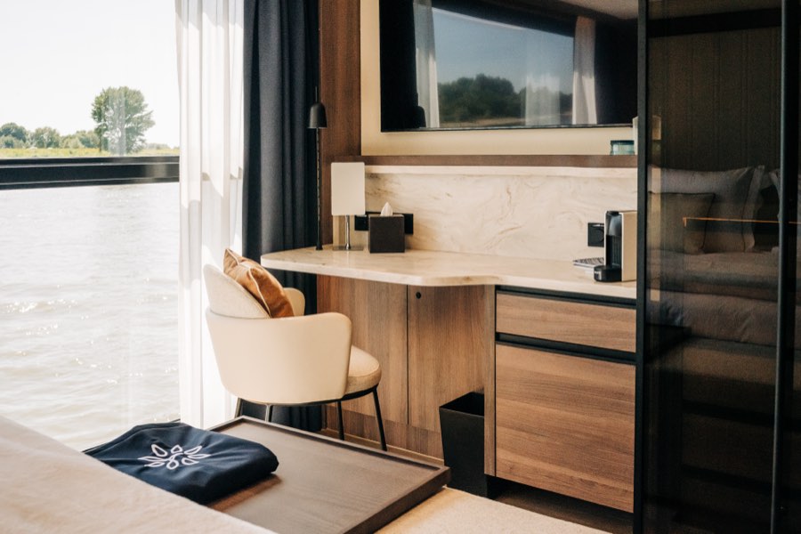 A stateroom desk and vanity area with a river-view window